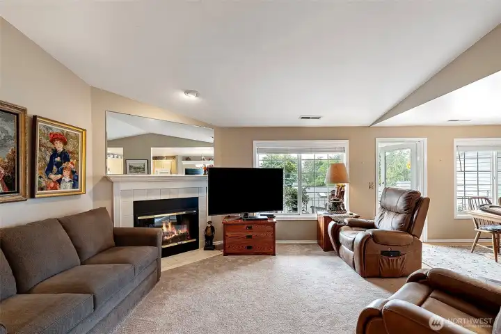 Spacious open-concept living area featuring a seamless flow between the kitchen, dining room, and living room, with direct access to the front deck for effortless entertaining.