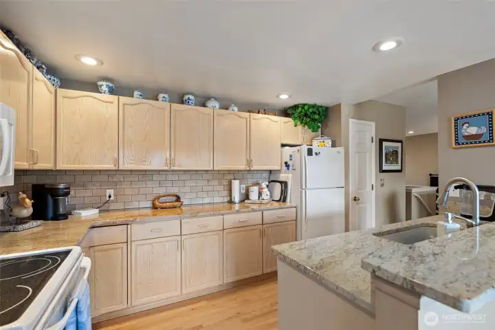Beautiful kitchen with gorgeous granite countertops, under-mount sink, tile backsplash, lovely cabinetry with ample storage, recessed lighting, and all appliances included.