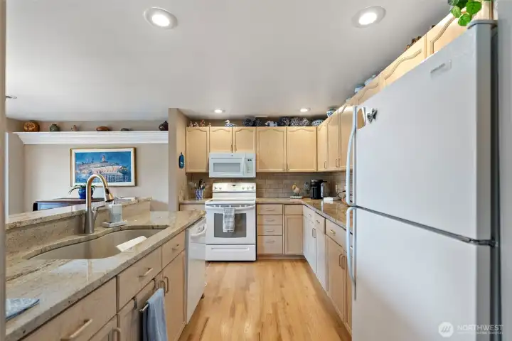 Hardwood floors accent the kitchen beautifully, creating a seamless flow into the open-concept living area and highlighting the home's warm, inviting atmosphere.
