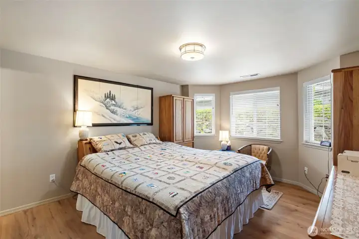The primary bedroom features durable vinyl plank flooring, an en-suite bathroom, and a spacious walk-in closet.
