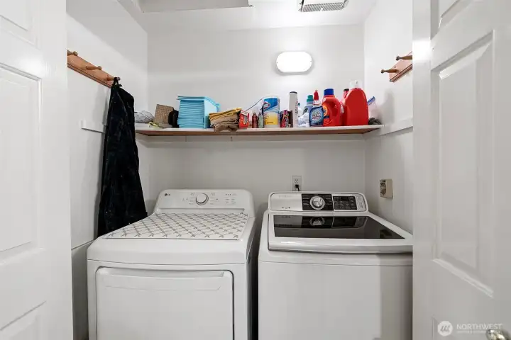 Utility closet located in the main guest bath, concealed by bifold doors. These appliances remain with the home.