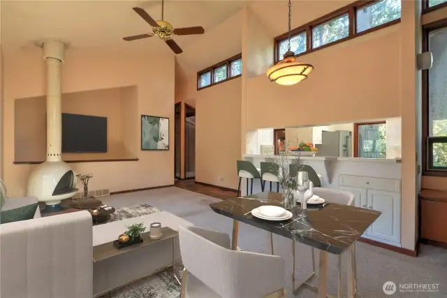 Living Room with Firehood for cozy Entertaining, Dining Area, Eating Bar & Soaring Ceilings accented with Windows! Virtually Staged