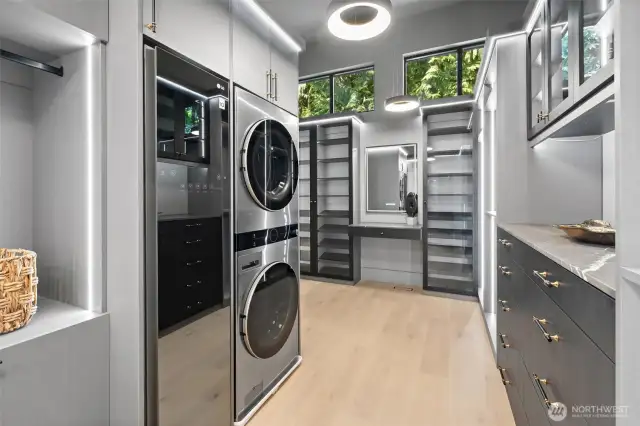 Primary closet complete with washer, dryer, and wardrobe steamer.