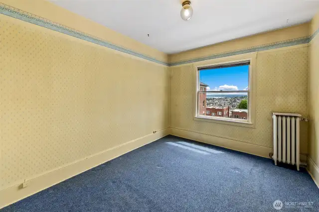 Your east facing bedroom also have water views.  You can see the hardwood floors under the radiator.