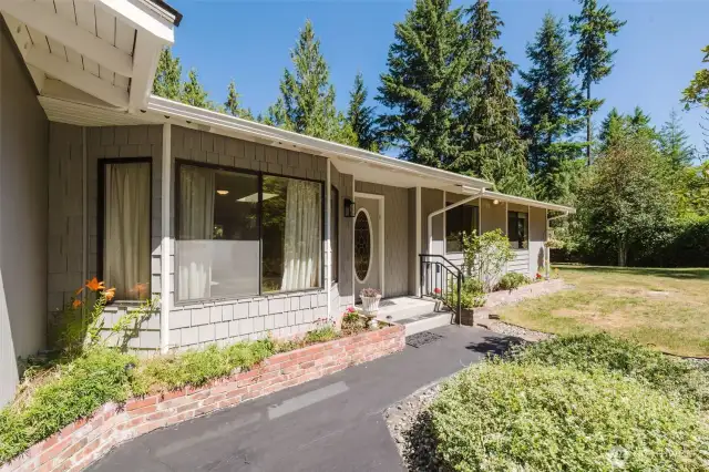 A neat and tidy front porch area welcomes you with simple elegance, clean lines, curated landscaping, and a touch of personality. Shake accents surrounding the bay window add warmth and texture to the exterior, creating an inviting first impression and enhancing the curb appeal.