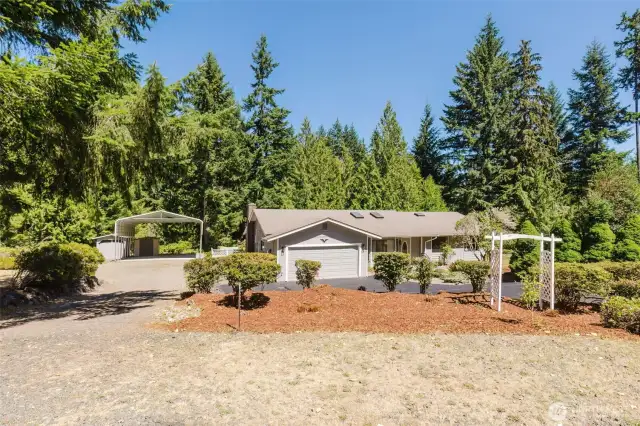 Set on a shy acre of serene Northwest beauty, there’s plenty of space to garden, relax, or entertain outdoors. Notice the covered RV parking plus two storage sheds!