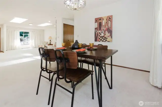 The dining room blends into the formal living room, light filters in through the skylights and large windows. Entertain with ease, just a few steps to the kitchen.
