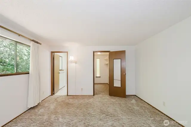 Primary Bedroom looking towards the huge walk in closet on the right and the private primary bath on the left.