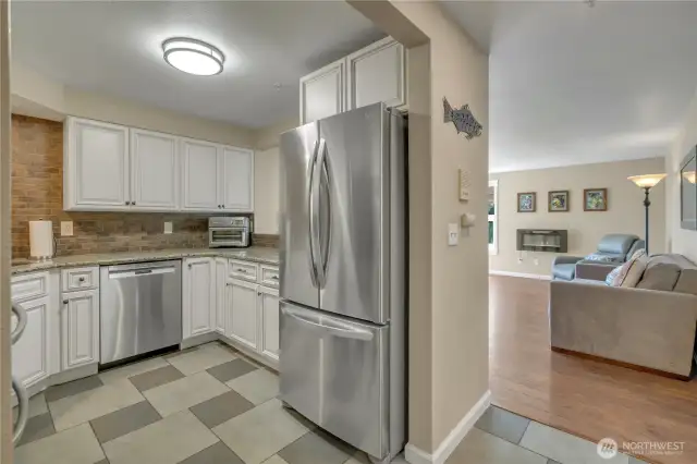 The kitchen has ample custom cabinetry, beautiful granite countertops, newer stainless steel appliances---even an air fryer! The full wall, subway tiled backsplash is a bonus!