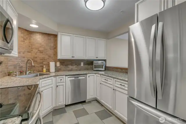 Here's another view of the kitchen and the double oven with glass top, Bosch dishwasher, microwave, and refrigerator are top of the line! Notice the 'insta-hot' water faucet next to the kitchen faucet!