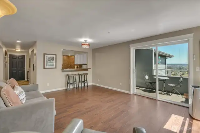Here is a view from the corner of the living room, and you can see the panoramic views of the territory and the city through the sliding glass door. The flooring on the deck is a Trex type, making it easy to maintain! What a spacious open floor plan!