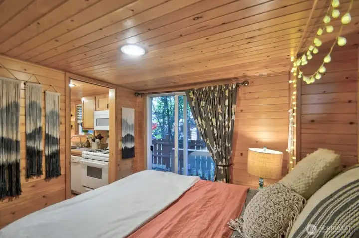 BEDROOM WITH QUEEN BED, SLIDING GLASS DOOR OPENS TO SMALL DECK