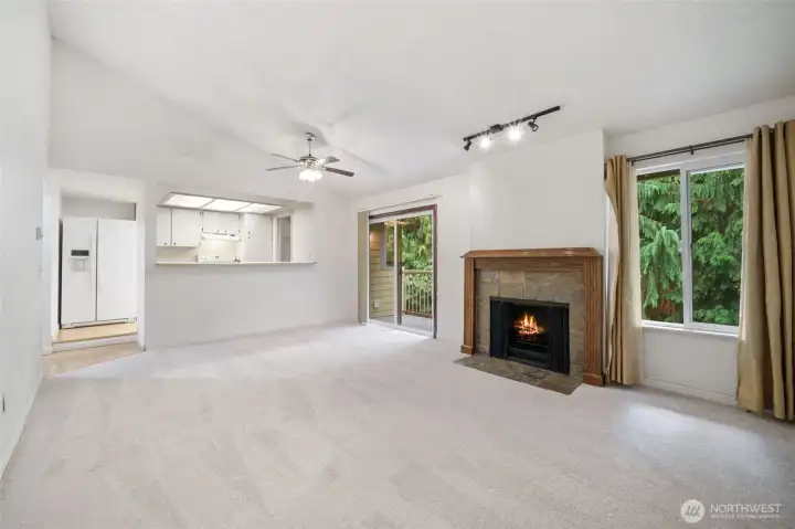 Bright and open living room with vaulted ceilings. A cozy fireplace adds warmth and charm.