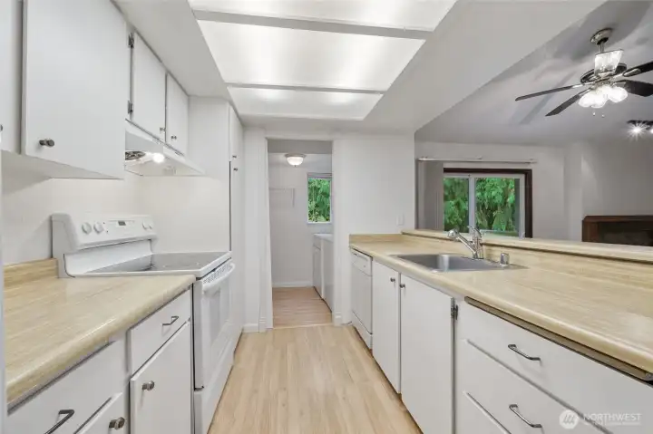 Bright kitchen with white cabinetry and appliances. A kitchen pass-through keeps conversation flowing.