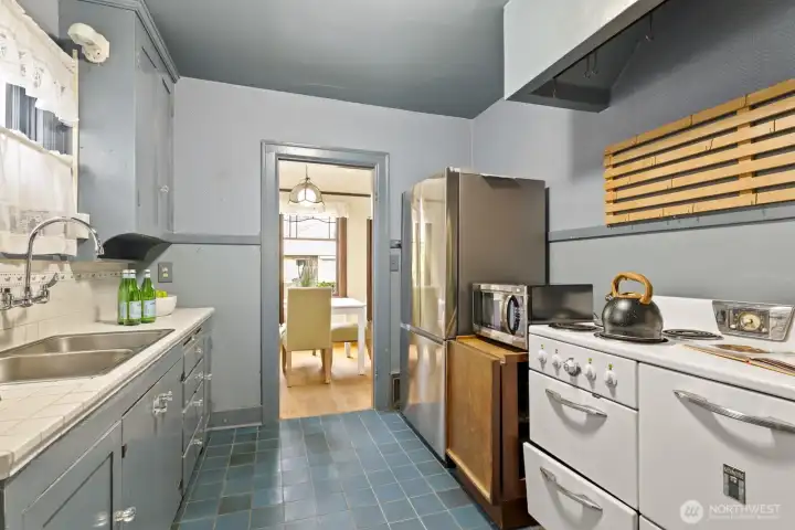 Whip up culinary creations in the kitchen, outfitted with a newer fridge, ample storage space, and a cool vintage range.