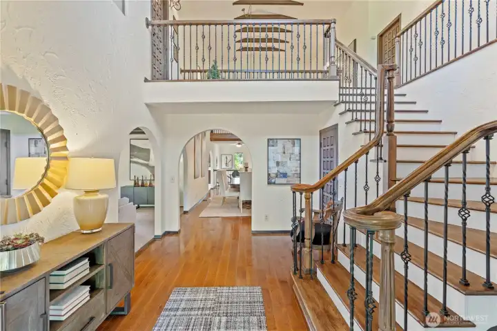 Breathtaking entryway showcases the beautiful wood and iron banisters and towering ceilings.