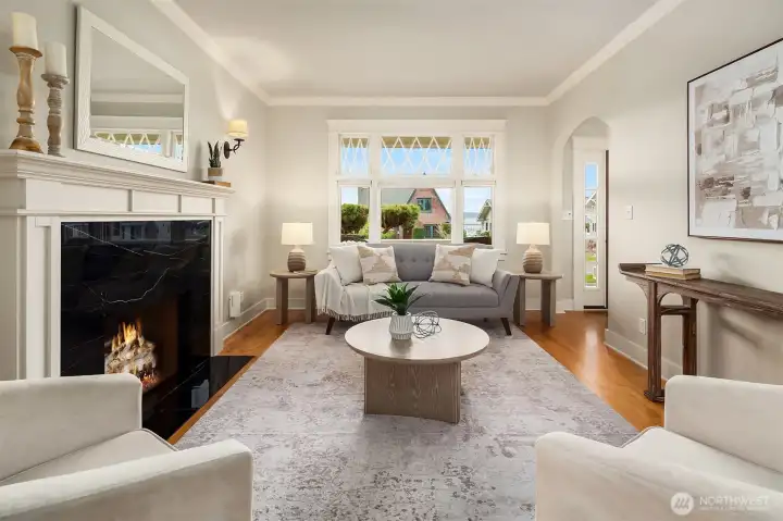 Living room offering large windows and Sound views. Fire added for visual (buyer to verify functionality).