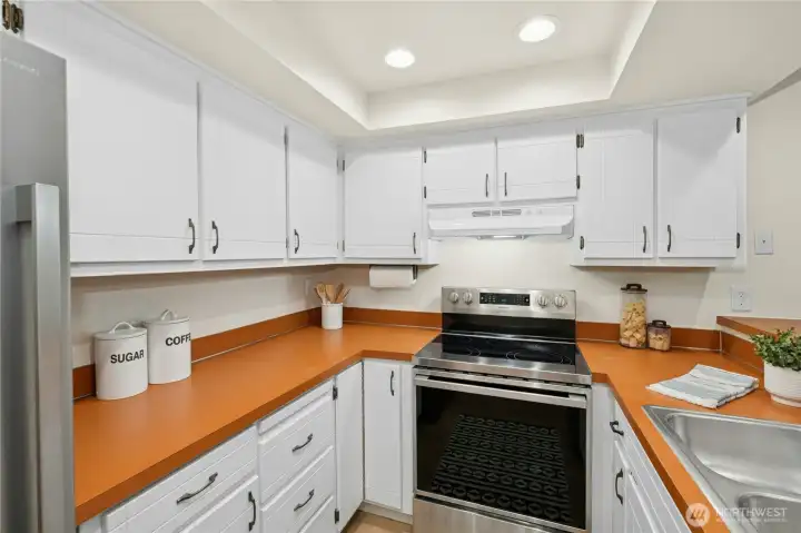 The efficient U-shaped kitchen has brand new stainless appliances, pantry, and an eating bar.