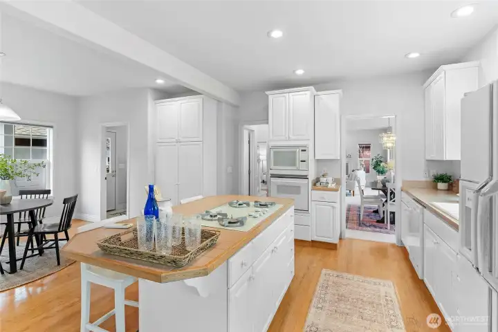 Open space kitchen work area, breakfast bar, dining area, and cooktop kitchen island.