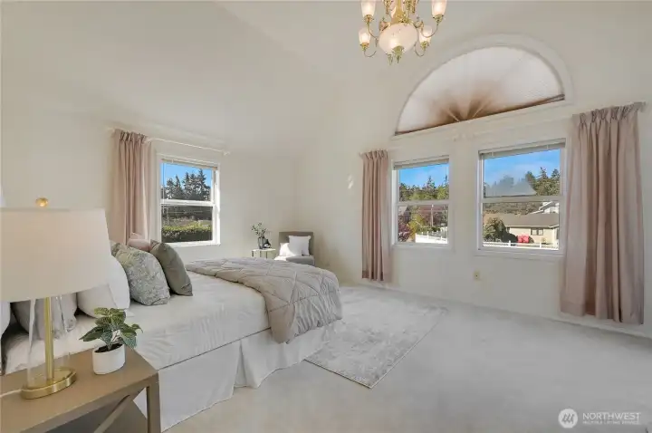 Primary Bedroom with vaulted ceiling, west-facing windows overlooking the gardens