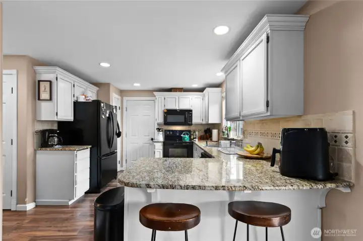 Kitchen w/gorgeous slab granite countertops & eat in bar