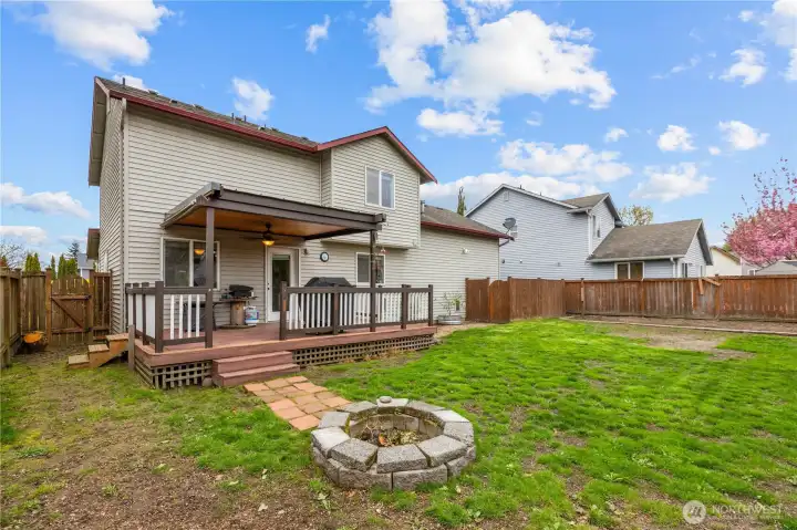 Spacious backyard with firepit and raised garden beds for