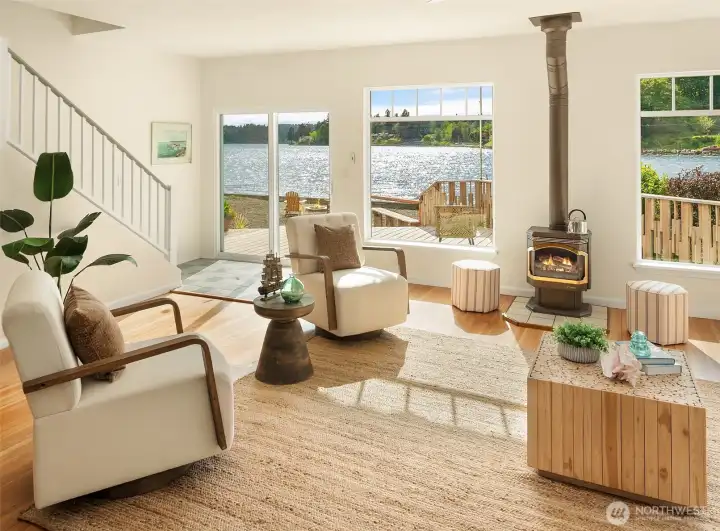 Open floor plan with cozy stove and real hardwood floors. Beautiful big windows for enjoying the water views. Look at the sparkle on the water -- it lights up the whole room.
