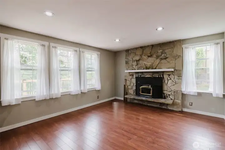 Living room with lots of windows bringing in the natural light   Fireplace insert and Pergo flooring.