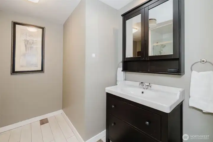 Bath with updated vanity, fixtures, newer shower and tile floors.