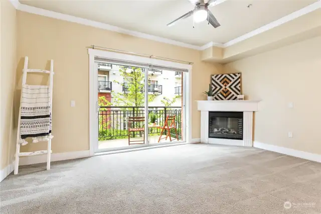 Spacious living room with 9' ceilings, cozy fireplace, and slider out onto the balcony.