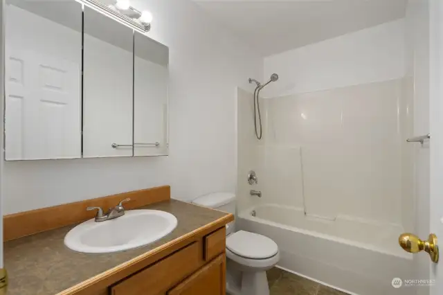 Main floor full bathroom featuring a shower-tub combination, for convenience and comfort.