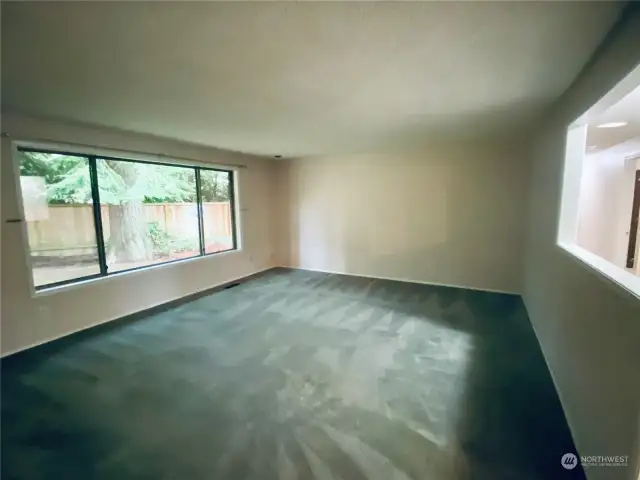 Formal living room boasts a ton of natural light and faces the fenced in back yard.