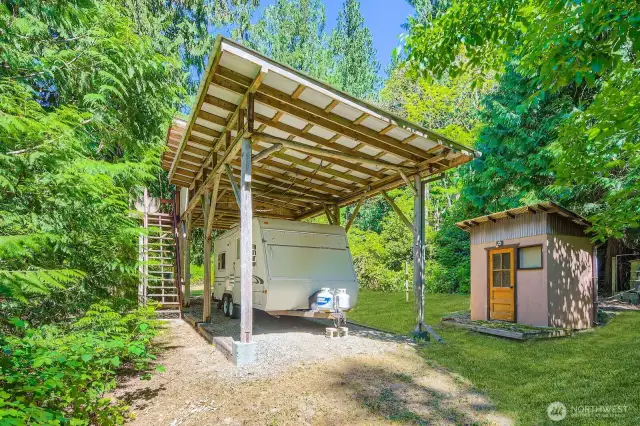 Covered RV parking at North side of lower lot - included electricity along with a small bath house and little hideaway room above - kid clubhouse