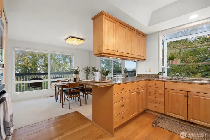 The kitchen has the oak hardwood flooring and beautiful maple cabinets with granite countertops. There is a garden window at the kitchen sink to take in the natural views and birds.