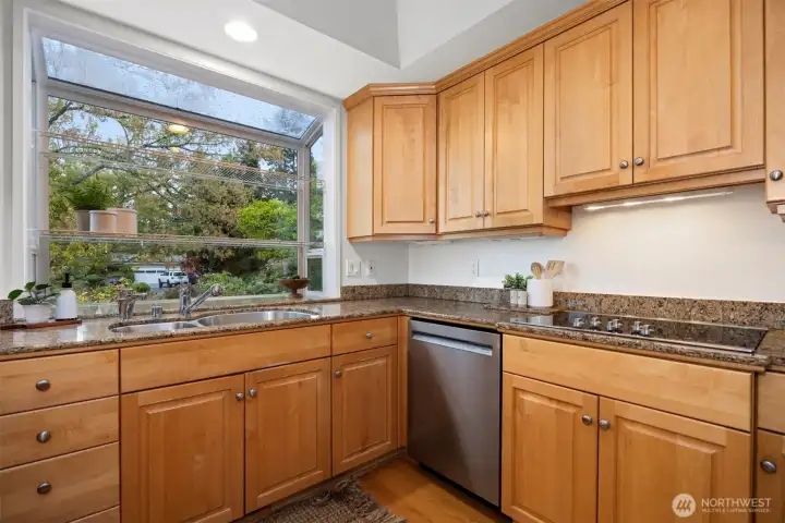 The updated kitchen has an electric cooktop and a separate wall oven with a built-in microwave with a lot of cabinet and countertop storage.