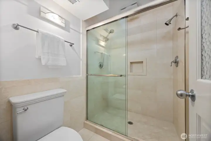 The shower has dual heads and controls.