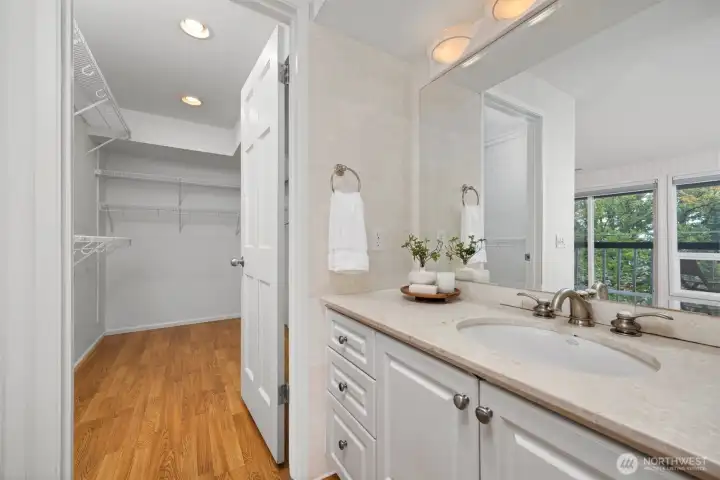 There is a large walk-in closet with additional storage space on the other side of the vanity.