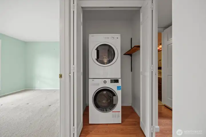 The stackable washer and dryer is between the second bedroom and 3/4 bath on the lower level.