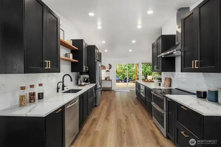 Modern kitchen features quartz countertops, subway tile backsplash, stainless appliances and plenty of cabinet storage