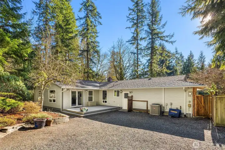 A second deck for lounging. Convenient access door off the garage. Note the A/C and generator that will stay with the home
