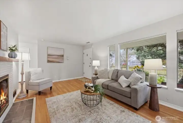 View of living room toward front door and large picture window allowing the outdoors to enter into this cozy living space!