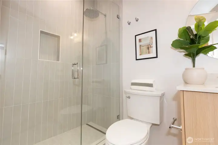 Primary bedroom 3/4 bath with custom tile work and framless glass shower enclosure Primary bedroom 3/4 bath with custom tile work and framless glass shower enclosure
