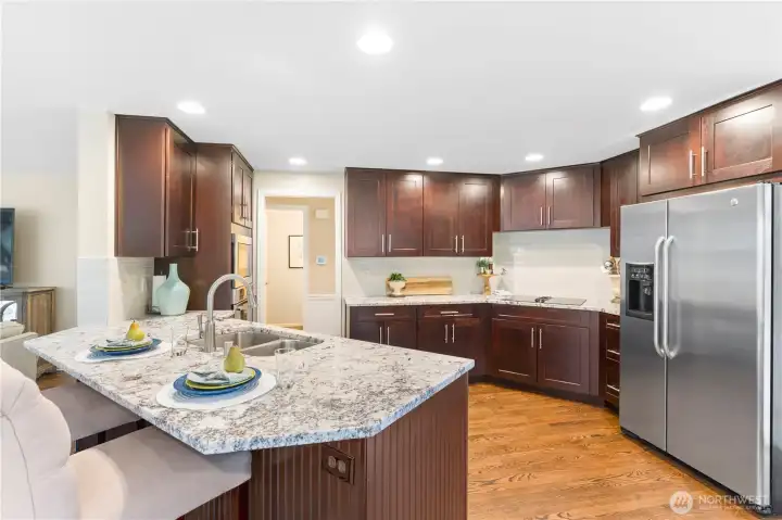 Remodeled in 2016, the kitchen blends thoughtful functionality with timeless finishes—featuring custom pull-out drawers, GE appliances, soft-close cabinetry, a tile backsplash, convection oven, and a dedicated dry bar. Granite countertops finish the space, creating a true chef’s kitchen designed for both everyday ease and elevated entertaining.