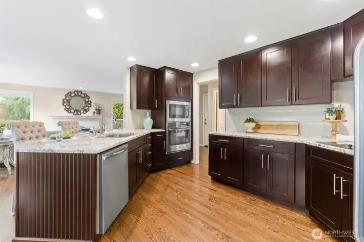 Remodeled in 2016, the kitchen blends thoughtful functionality with timeless finishes—featuring custom pull-out drawers, GE appliances, soft-close cabinetry, a tile backsplash, induction cooktop, convection oven, and a dedicated dry bar. Granite countertops finish the space, creating a true chef’s kitchen designed for both everyday ease and elevated entertaining.