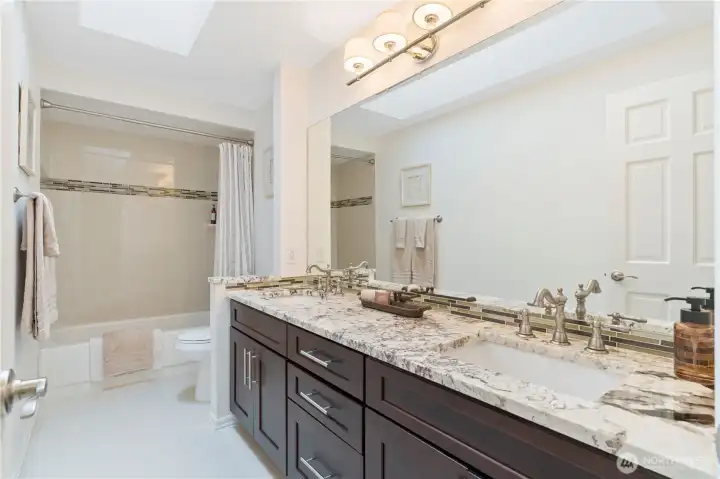 The upper-level bathroom was remodeled in 2016 and features granite countertops, tile flooring, and a tile shower surround.