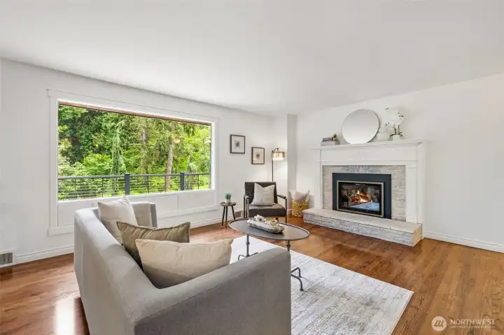 Warm and inviting living space with a beautiful fireplace and peaceful natural views.
