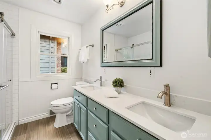 Stylish full bath with quartz counters and double vanity.
