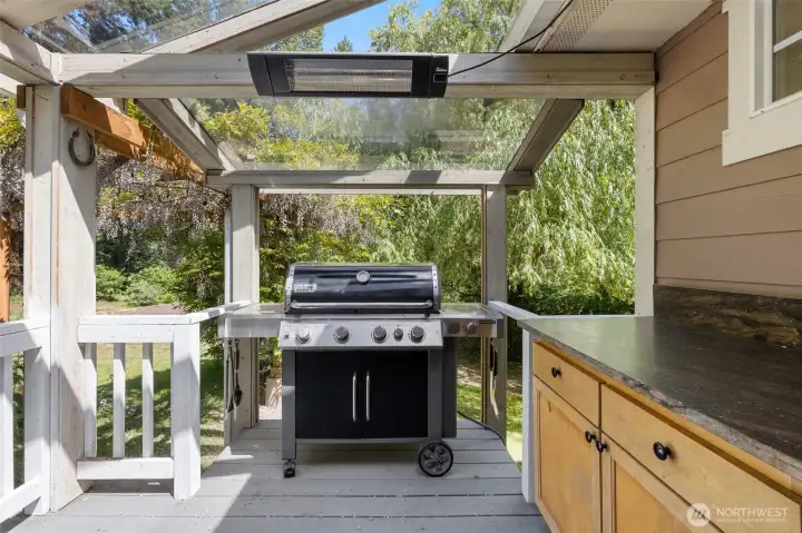 Covered Outdoor Barbecue Station. Enjoy comfortable year-round grilling with overhead heating, prep space, and convenient kitchen access.