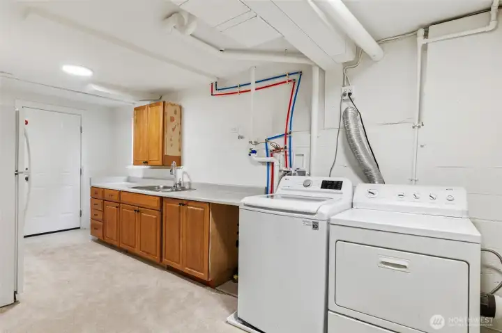 Spacious laundry area with utility sink and storage cabinetry.