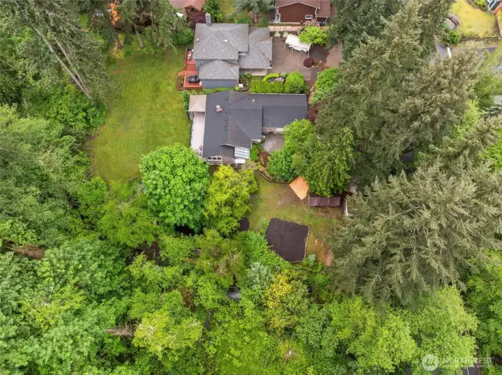 Sweeping aerial view captures the home’s private setting and generous outdoor space.